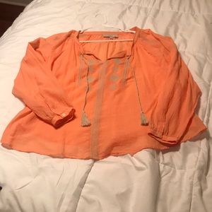 Long sleeve coral top with tie neck tassels.